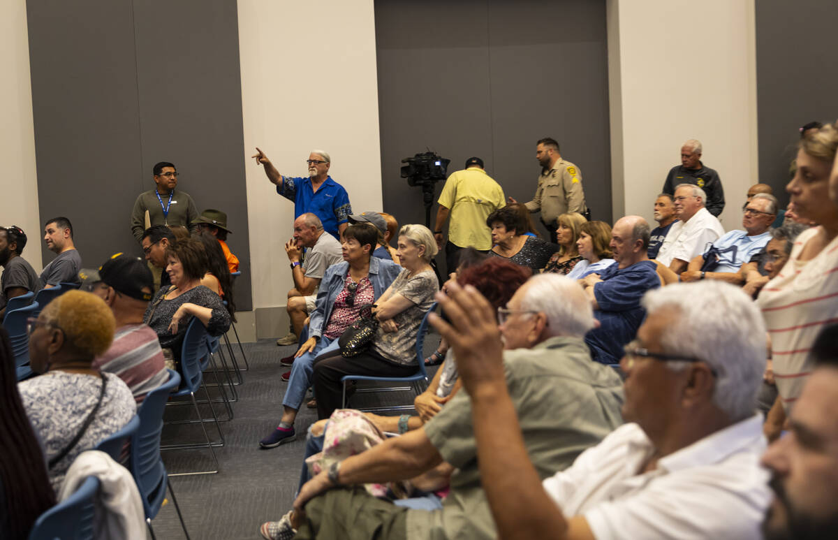 People raise their hands as others speak out while Clark County Commission Chairman Tick Segerb ...