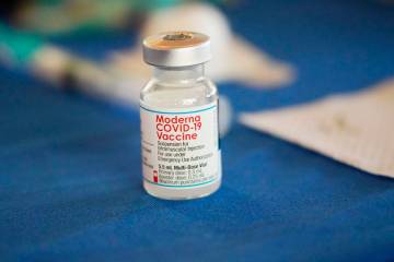 A vial of Moderna COVID-19 vaccine rests on a table at an inoculation station in Jackson, Miss. ...