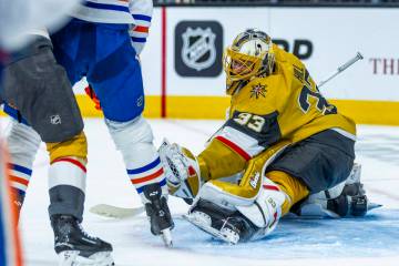 Golden Knights goaltender Adin Hill (33) grabs a puck as he defends the net from a shot by Edmo ...