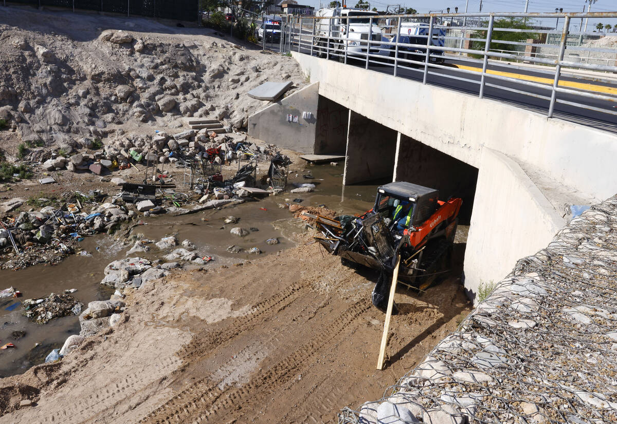 Contract workers remove debris from the wash area near Flamingo Road and Cambridge Street Tuesd ...