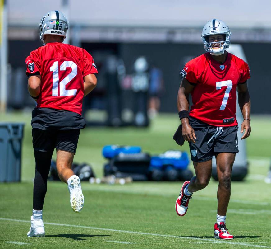 Raiders quarterback Geno Smith (7) and quarterback Aiden O'Connell (12) run about the field dur ...