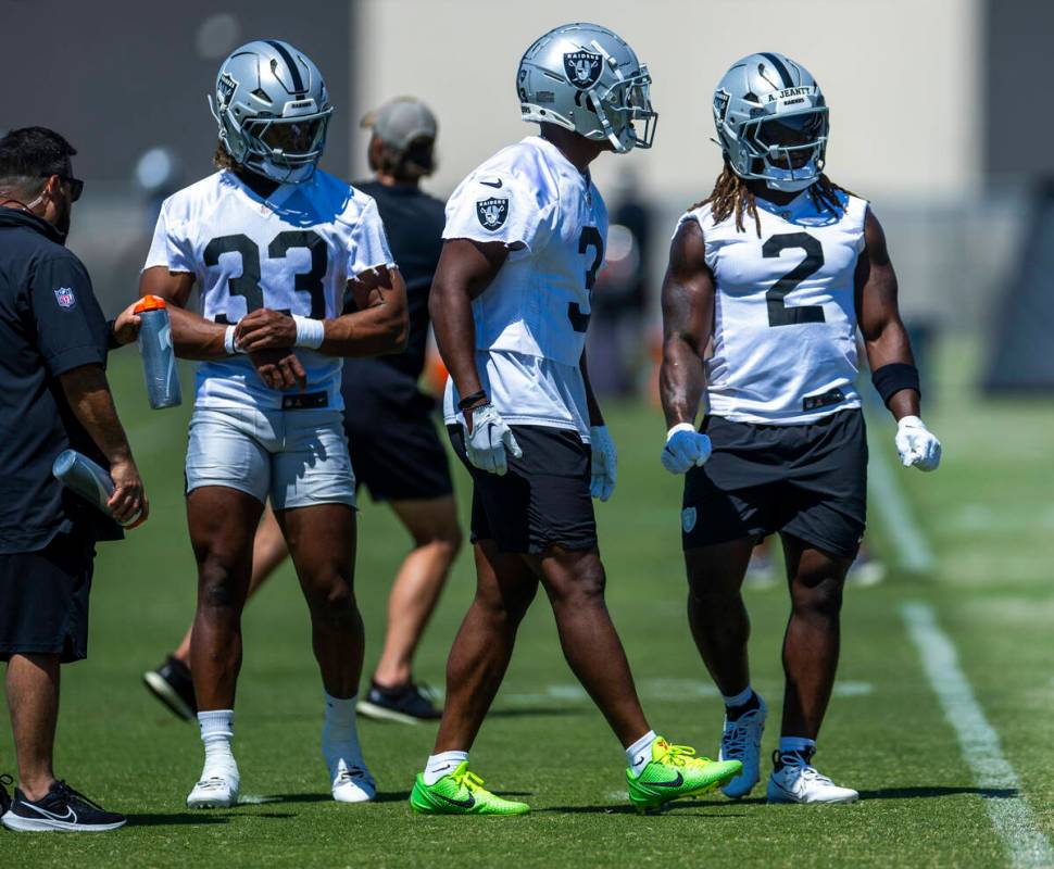 Raiders running backs Chris Collier (33), Zamir White (3) and Ashton Jeanty (2) watch teammates ...