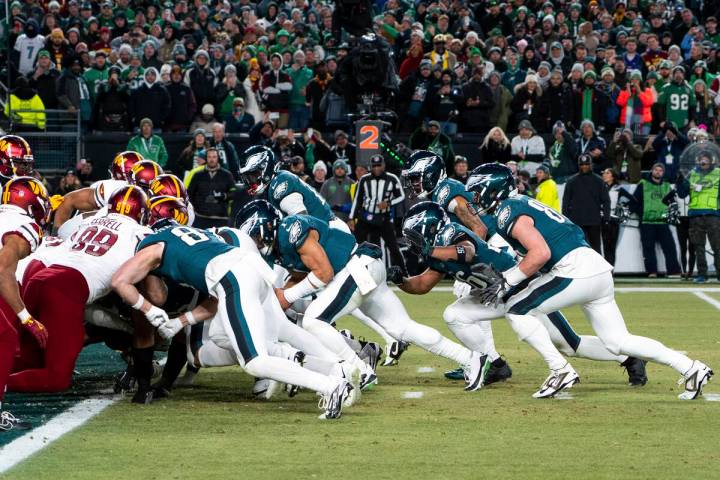 FILE - Philadelphia Eagles quarterback Jalen Hurts, center, and teammates run the tush push pla ...