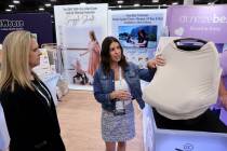 Nicole Noar, founder and CEO of Snuggle Shield, right, shows her product to Tai Kirby during th ...