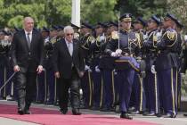 Lebanese President Joseph Aoun, left, and Palestinian President Mahmoud Abbas, center, review a ...