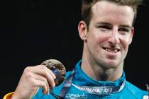 FILE - Australia's James Magnussen smiles as he hold the gold medal he won in the Men's 100m fr ...