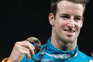 FILE - Australia's James Magnussen smiles as he hold the gold medal he won in the Men's 100m fr ...