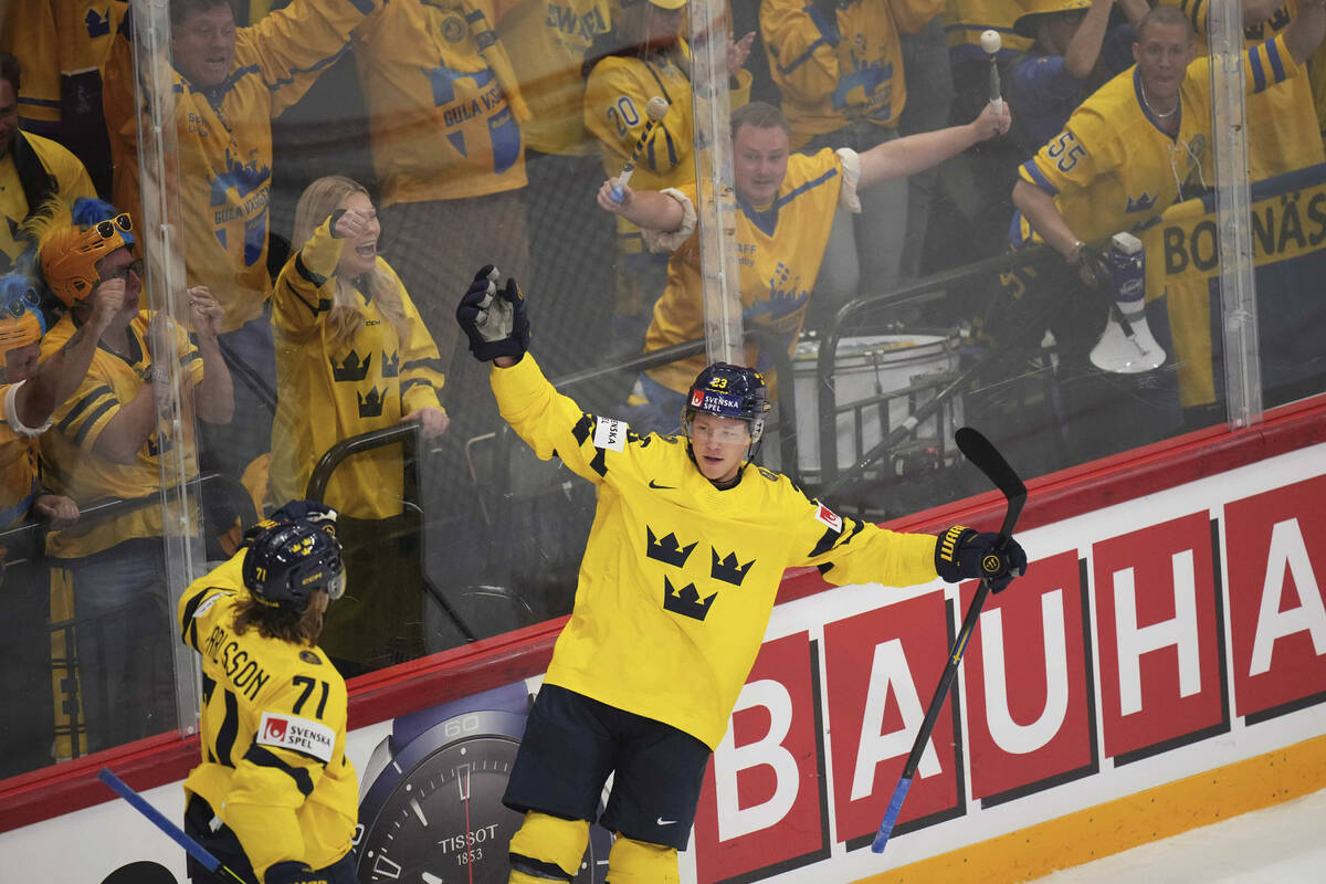 Fans cheer as Sweden's Lucas Raymond, middle, celebrates with William Karlsson (71) after scori ...