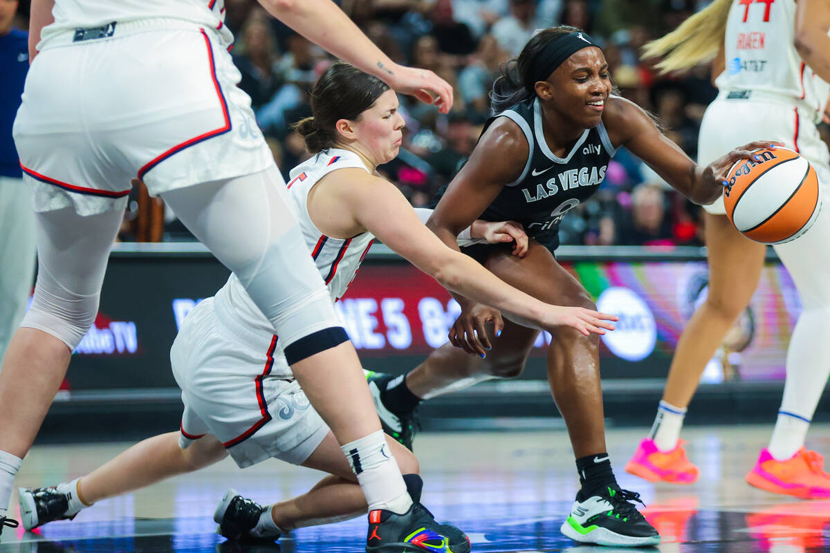 Aces guard Jackie Young (0) struggles to keep the ball in her grip during a WNBA basketball gam ...
