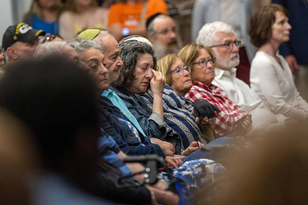 A mourner wipes away tears during a vigil for Sarah Milgrim and Yaron Lischinsky at the Jewish ...
