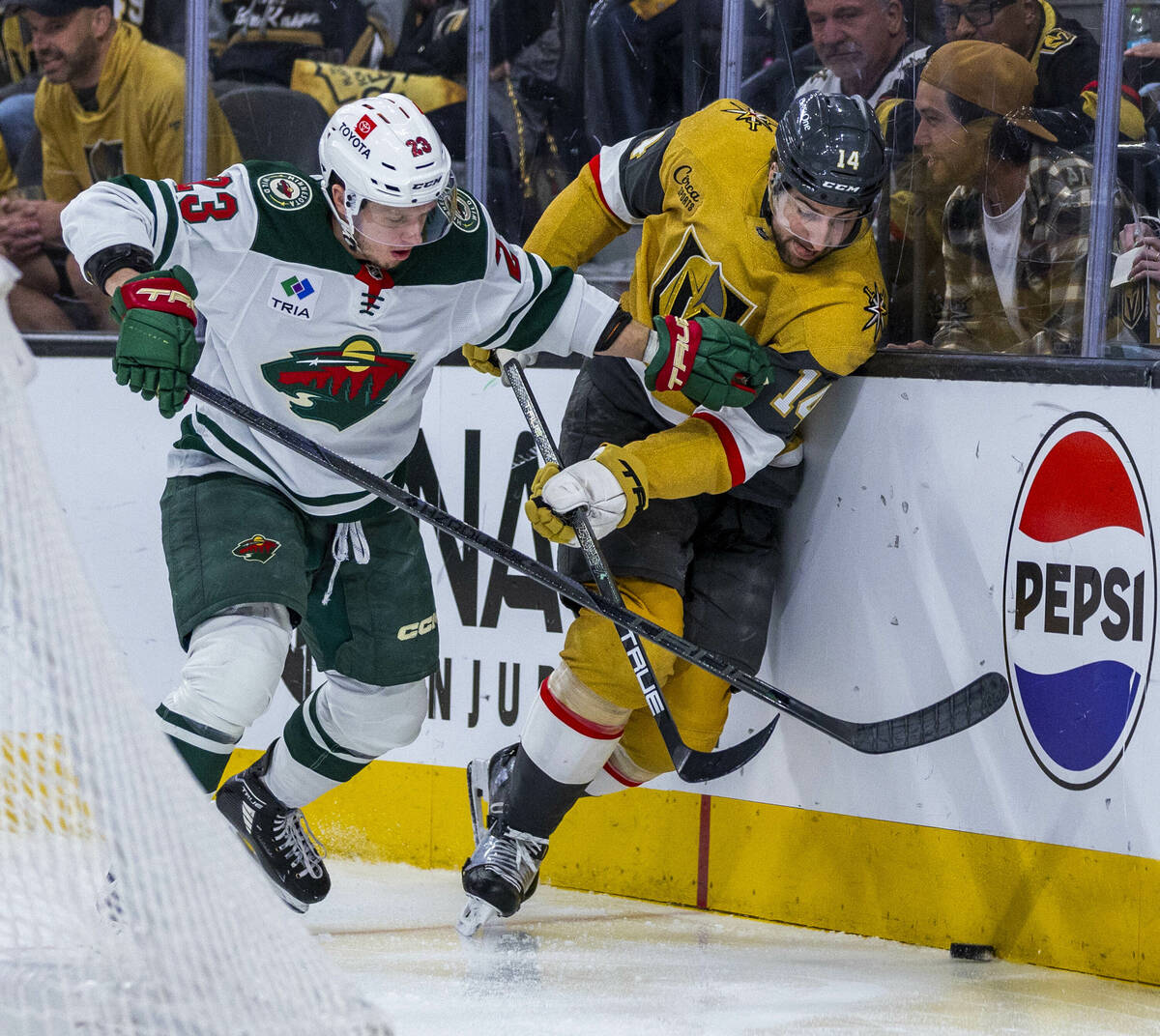 Golden Knights defenseman Nic Hague (14) fights to get to the puck as Minnesota Wild center Mar ...