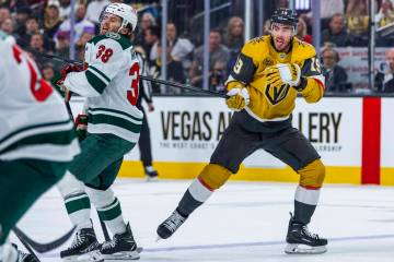 Golden Knights right wing Reilly Smith (19) has his stick held by Minnesota Wild right wing Rya ...