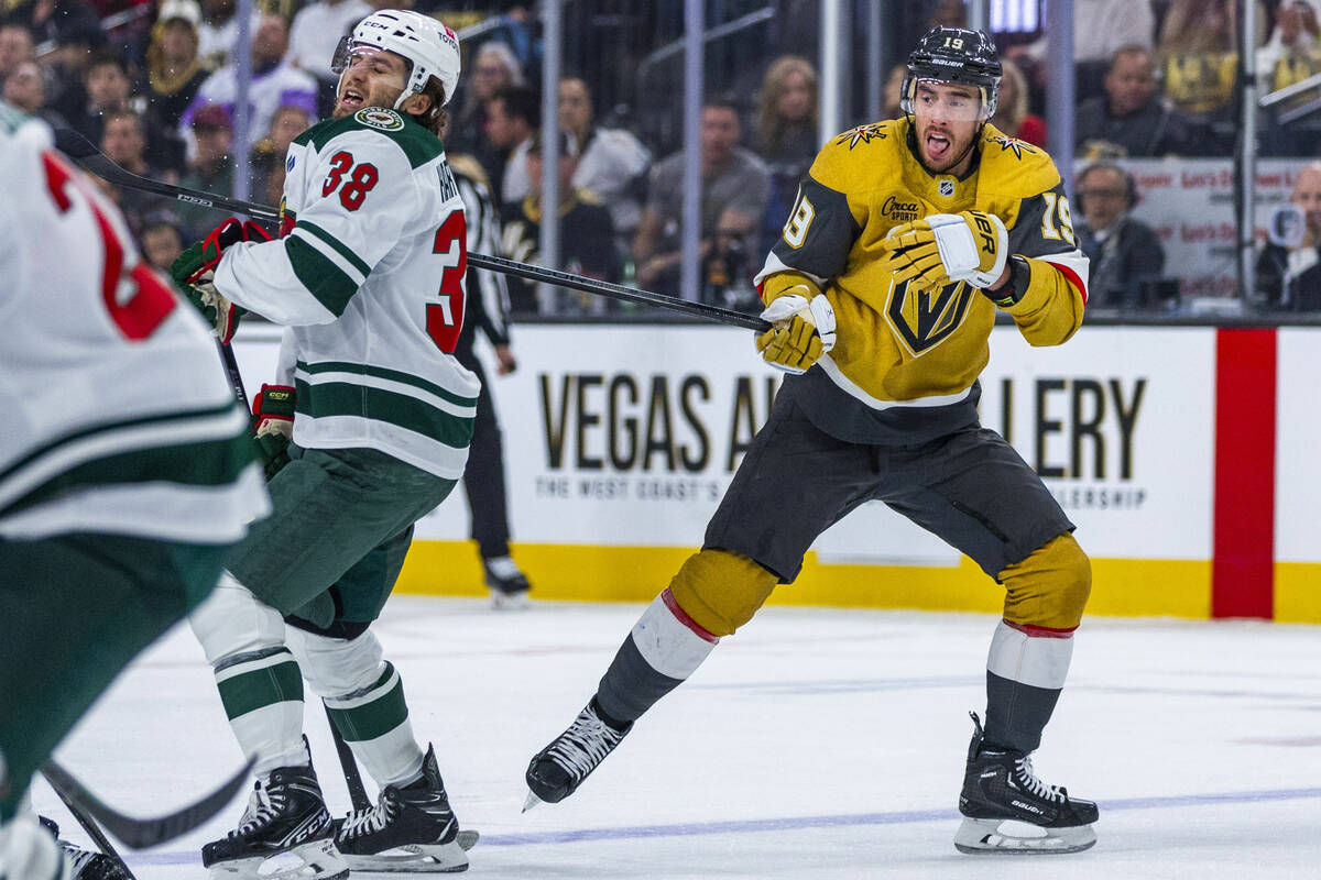 Golden Knights right wing Reilly Smith (19) has his stick held by Minnesota Wild right wing Rya ...