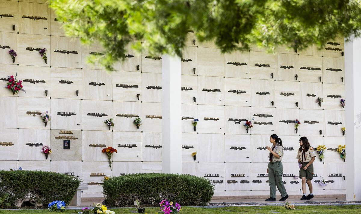 Scouting America troops walk past a mausoleum while placing American flags at the gravesites of ...