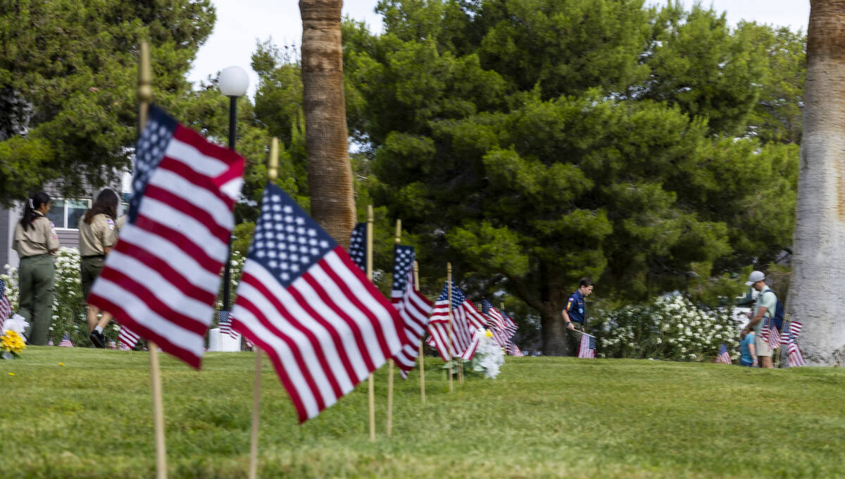 Scouting America troops assist with placing American flags at the gravesites of veterans at the ...