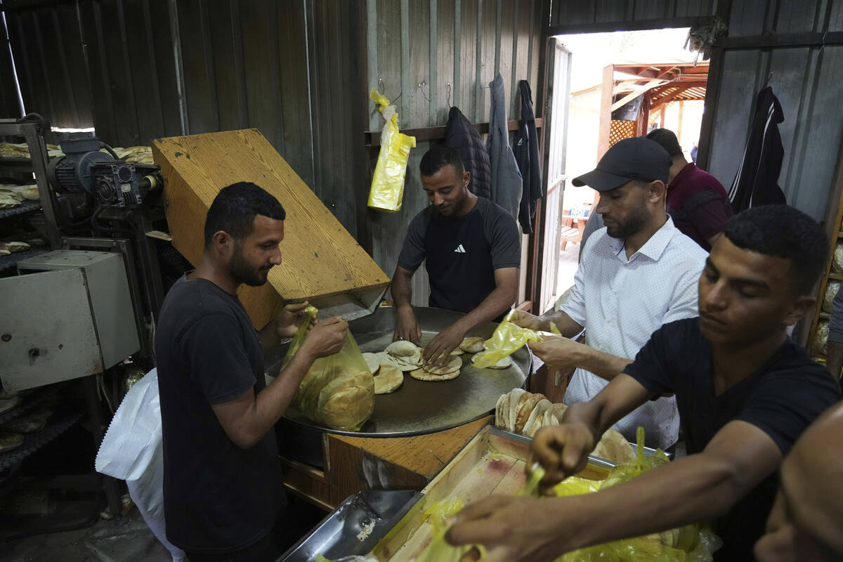 Palestinians bake bread after the World Food Program was able to bring in flour for the first t ...