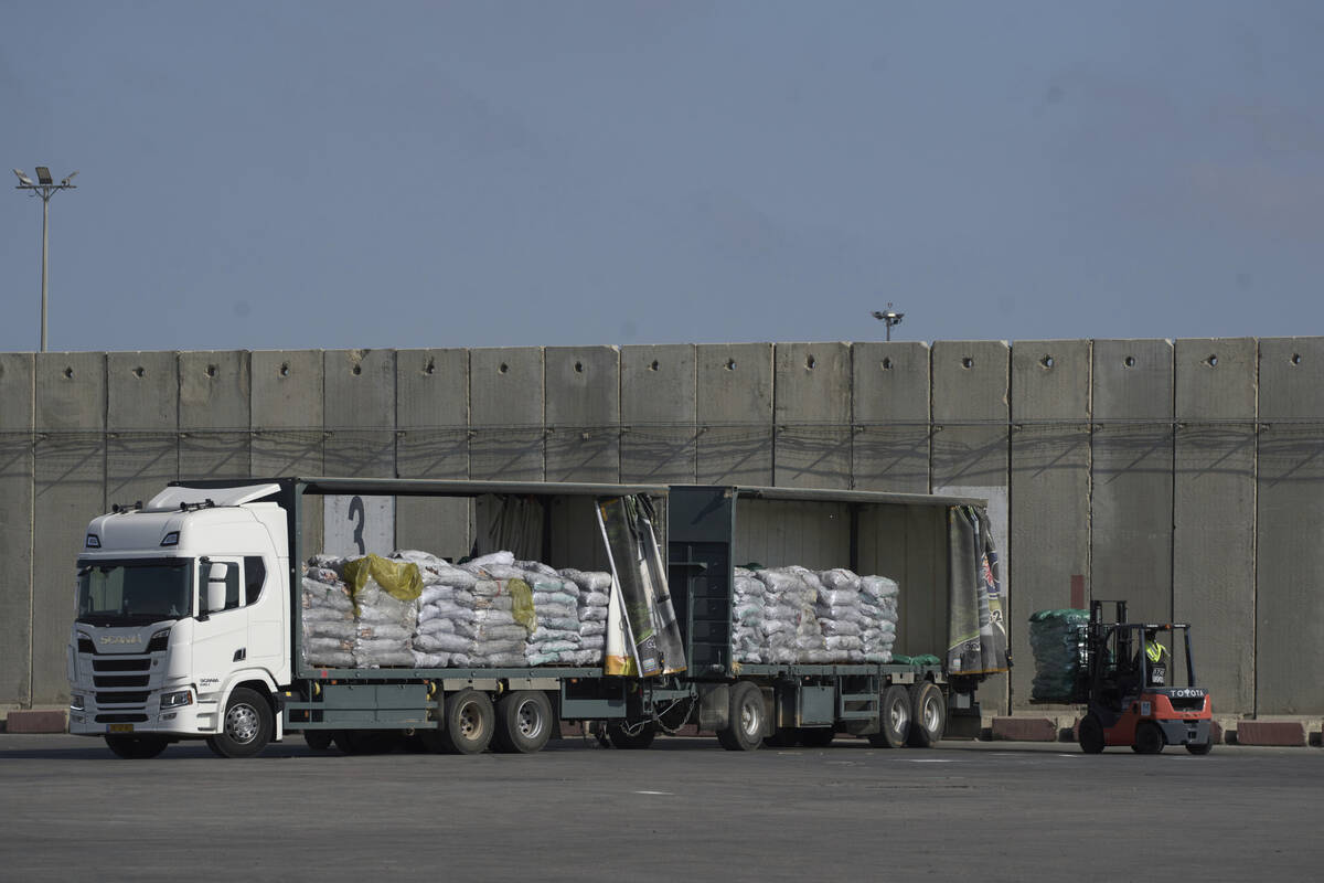 A worker unloads cargo from a truck carrying humanitarian aid for the Gaza Strip at the offload ...