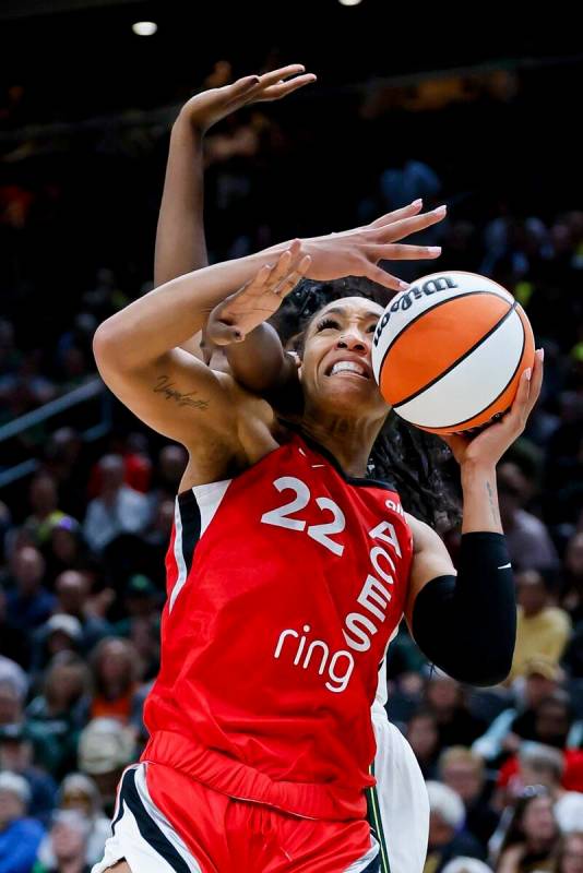 Seattle Storm forward Ezi Magbegor, behind, battles Las Vegas Aces center A'ja Wilson for a reb ...