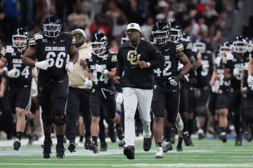 Colorado head coach Deion Sanders, center, takes the field with his team before the Alamo Bowl ...