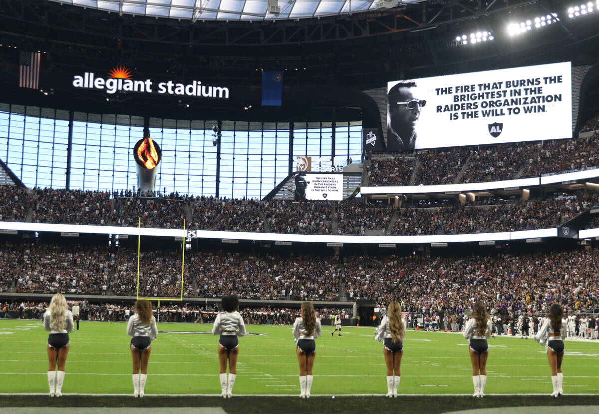 The Raiderettes stay on the field as the Al Davis Memorial Torch is lit before an NFL football ...