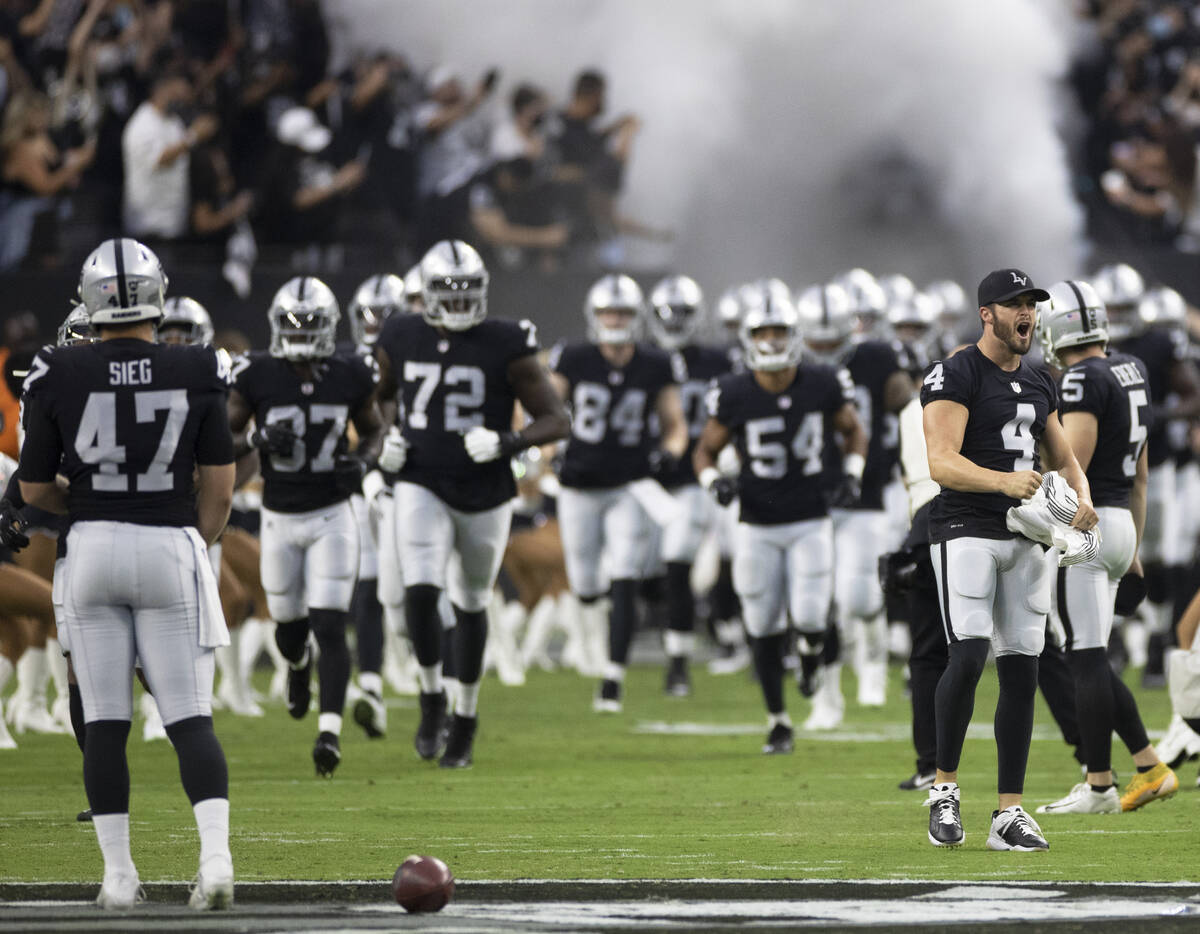 Raiders quarterback Derek Carr (4) leads Las Vegas out before the start of an NFL preseason foo ...