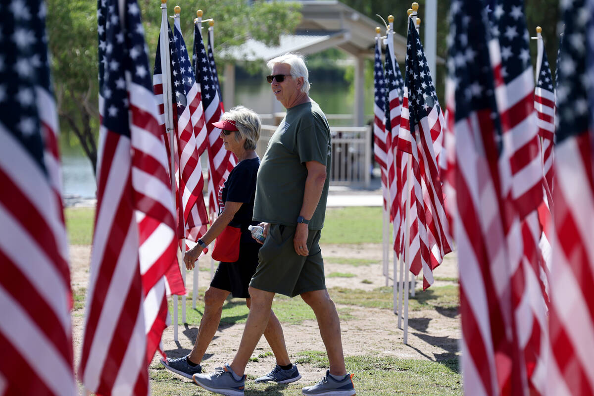 Lois and Rick Anderson of Henderson walk among flags during the Field of Honor ceremony at Corn ...
