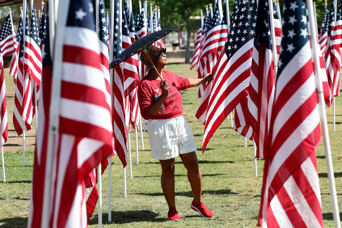 Dee Dee Temple of Henderson walks among flags during the Field of Honor ceremony at Cornerstone ...