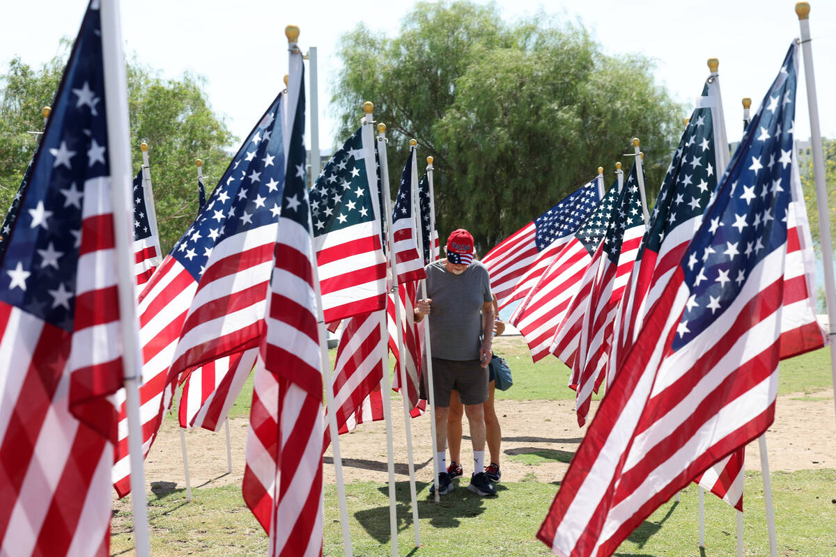 Ted Cooper checks a flag during the Field of Honor ceremony at Cornerstone Park in Henderson on ...