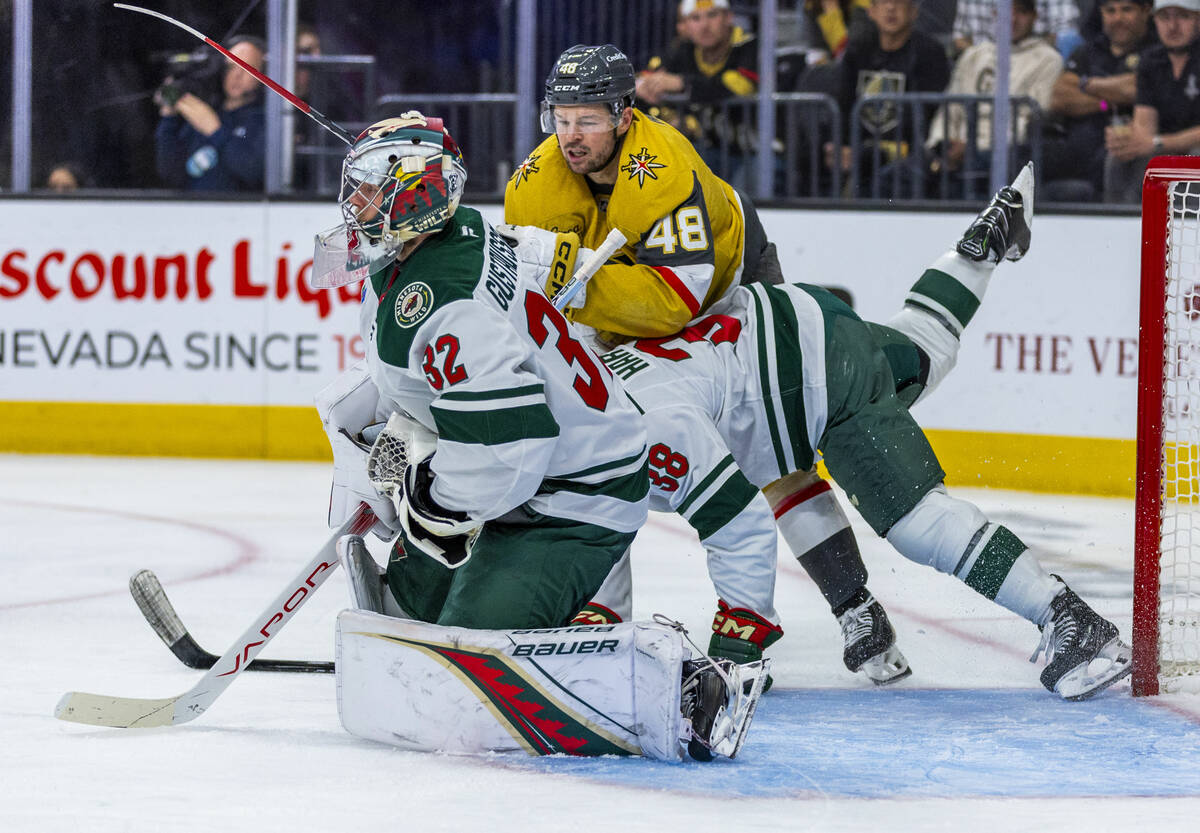 Golden Knights center Tomas Hertl (48) battles near the net with Minnesota Wild right wing Ryan ...