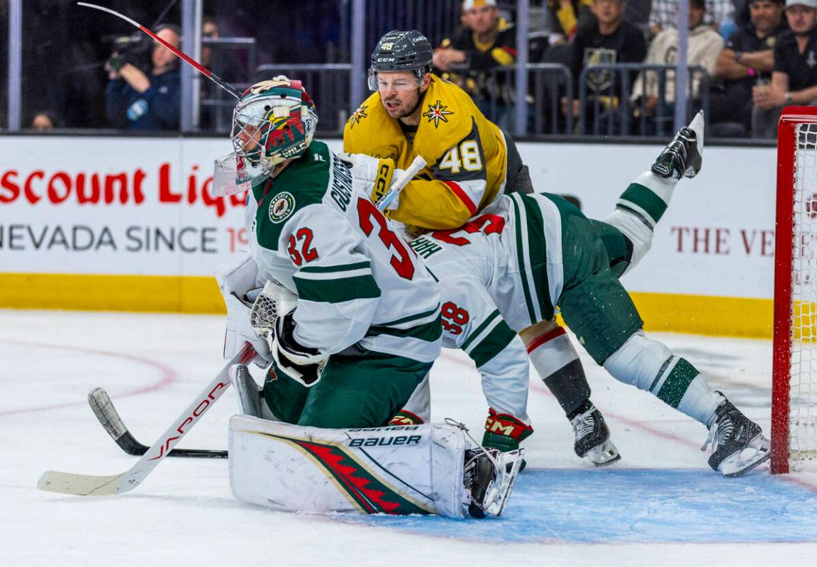 Golden Knights center Tomas Hertl (48) battles near the net with Minnesota Wild right wing Ryan ...