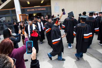 Graduating seniors at Chaparral High School are cheered on as they exit the building following ...