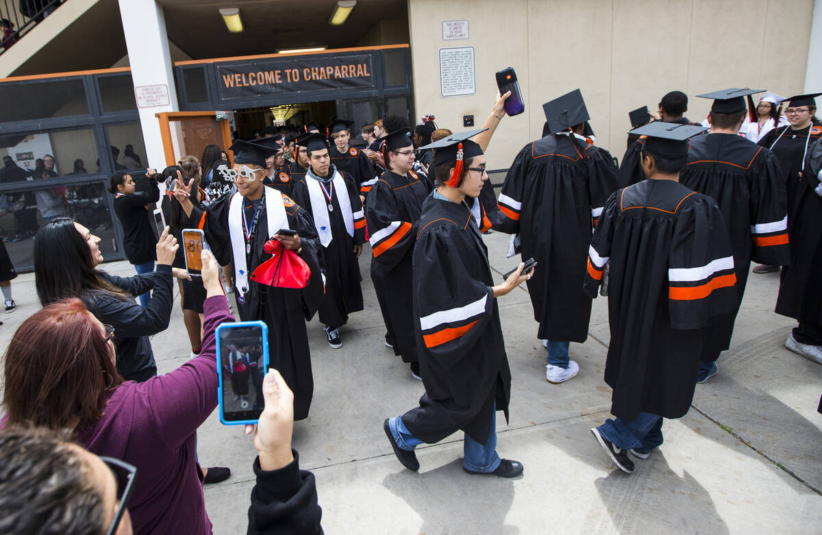 Graduating seniors at Chaparral High School are cheered on as they exit the building following ...
