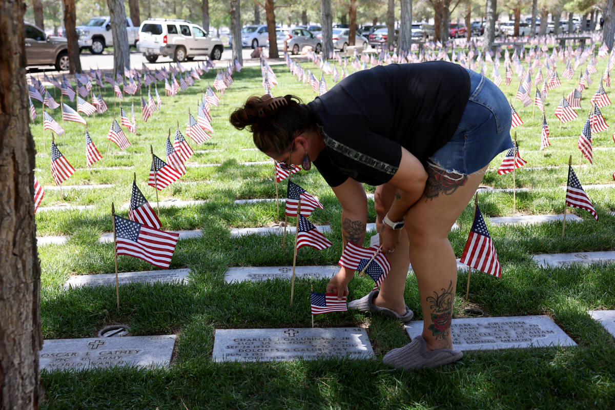 Dawn Mobley of Pahrump places flags on graves before the Memorial Day ceremony at the Southern ...