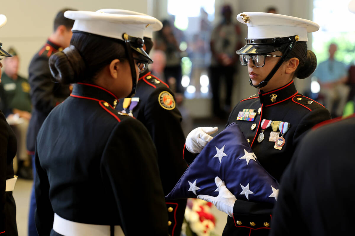 Members of the Desert Pines Marine Corps JROTC give a flag folding demonstration during the Mem ...