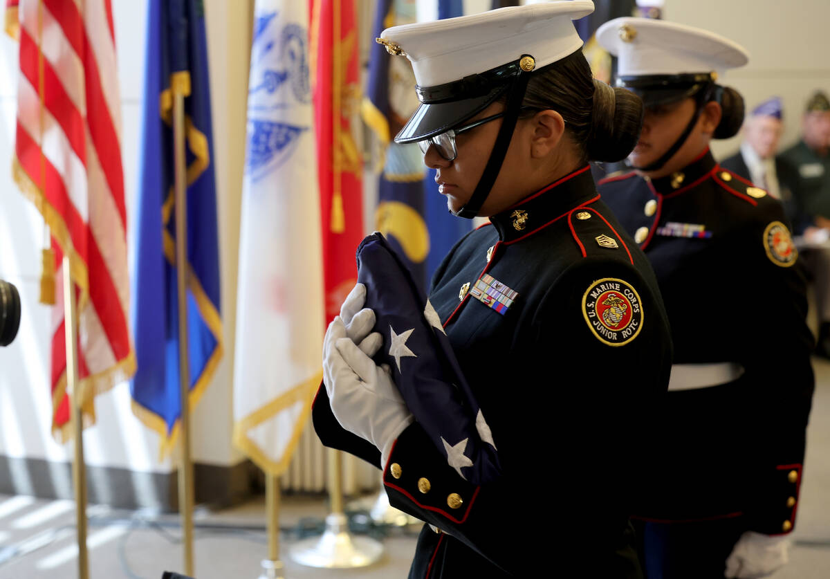Members of the Desert Pines Marine Corps JROTC give a flag folding demonstration during the Mem ...