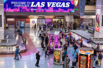 Travelers are seen at baggage claim in Harry Reid International Airport's Terminal 1 on the fir ...