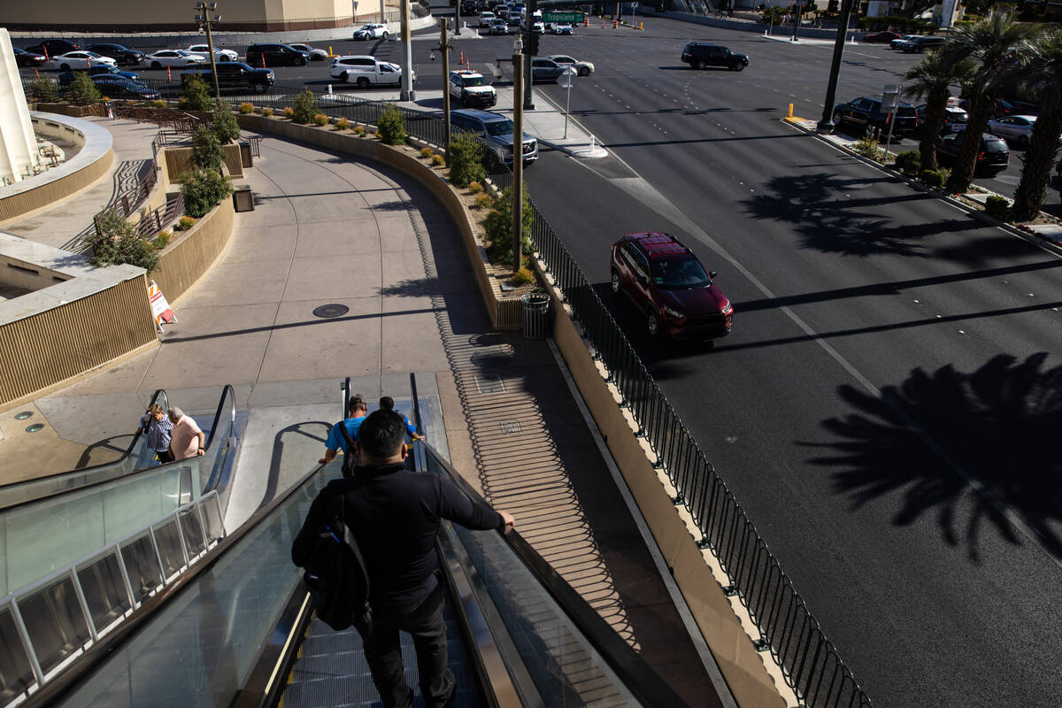 Pedestrians take an escalator as vehicles turn onto the Las Vegas Strip on Tuesday, April 29, 2 ...