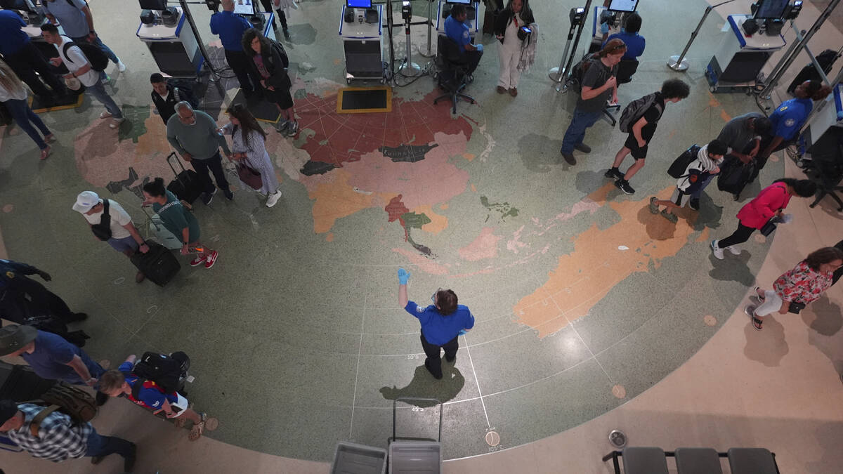 Travellers are directed to lines through security at Love Field airport, Friday, May 23, 2025, ...