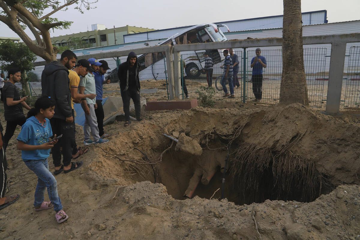 Palestinians inspect the site of an Israeli army airstrike on the European hospital in Khan You ...