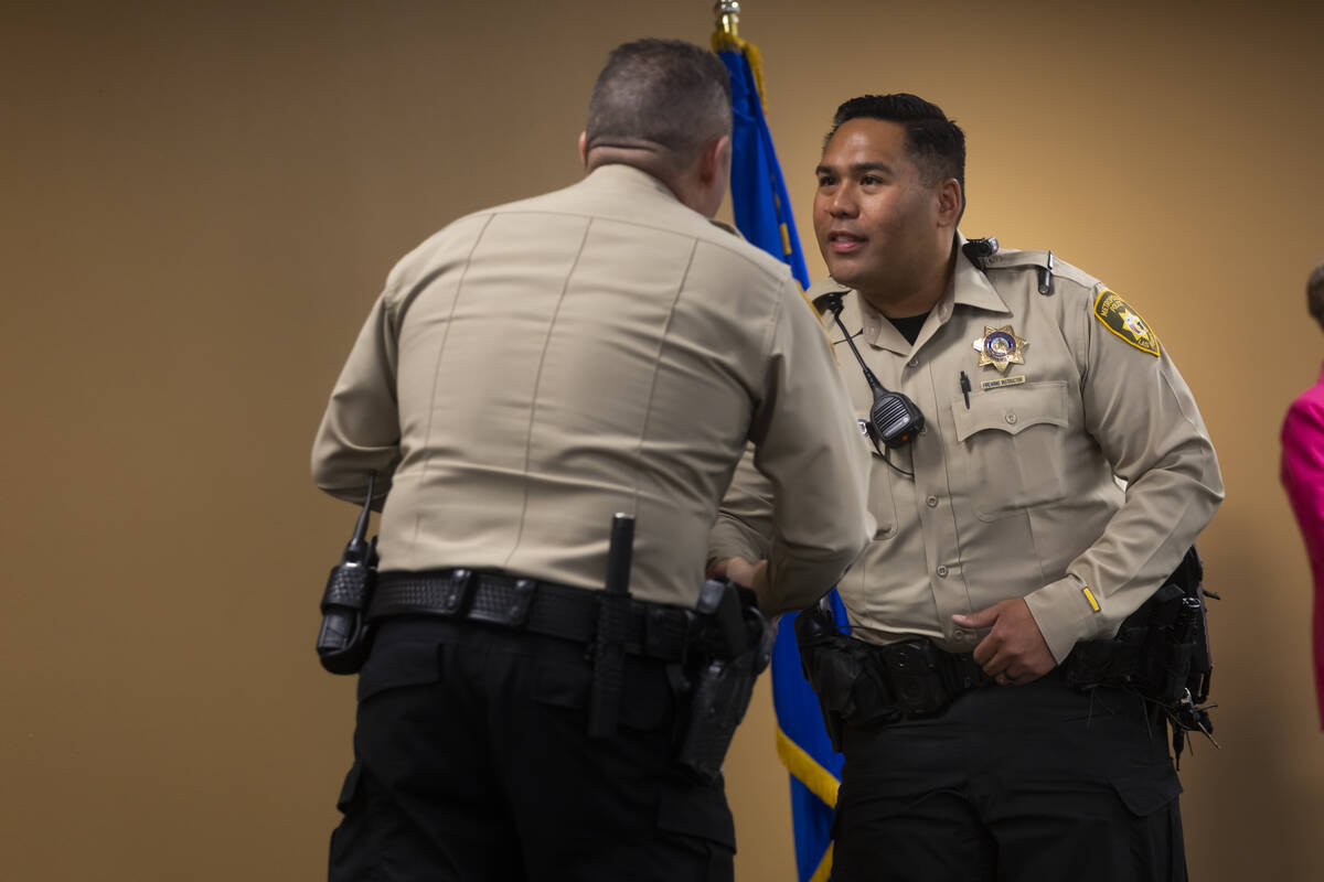 Officer Wilson Sumalpong, right, shakes hands with Undersheriff Andrew Walsh before being prese ...