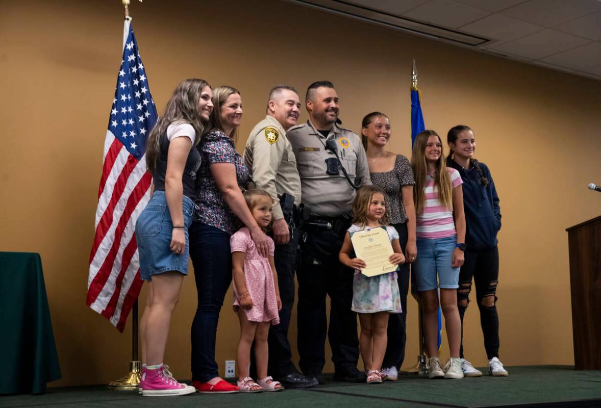 Officer Jason Rich, center, who saved a choking baby, stands with his family and Undersheriff A ...
