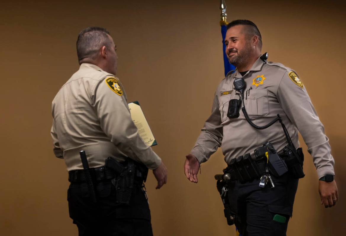 Officer Jason Rich, right, who saved a choking baby, is presented with the lifesaving award by ...