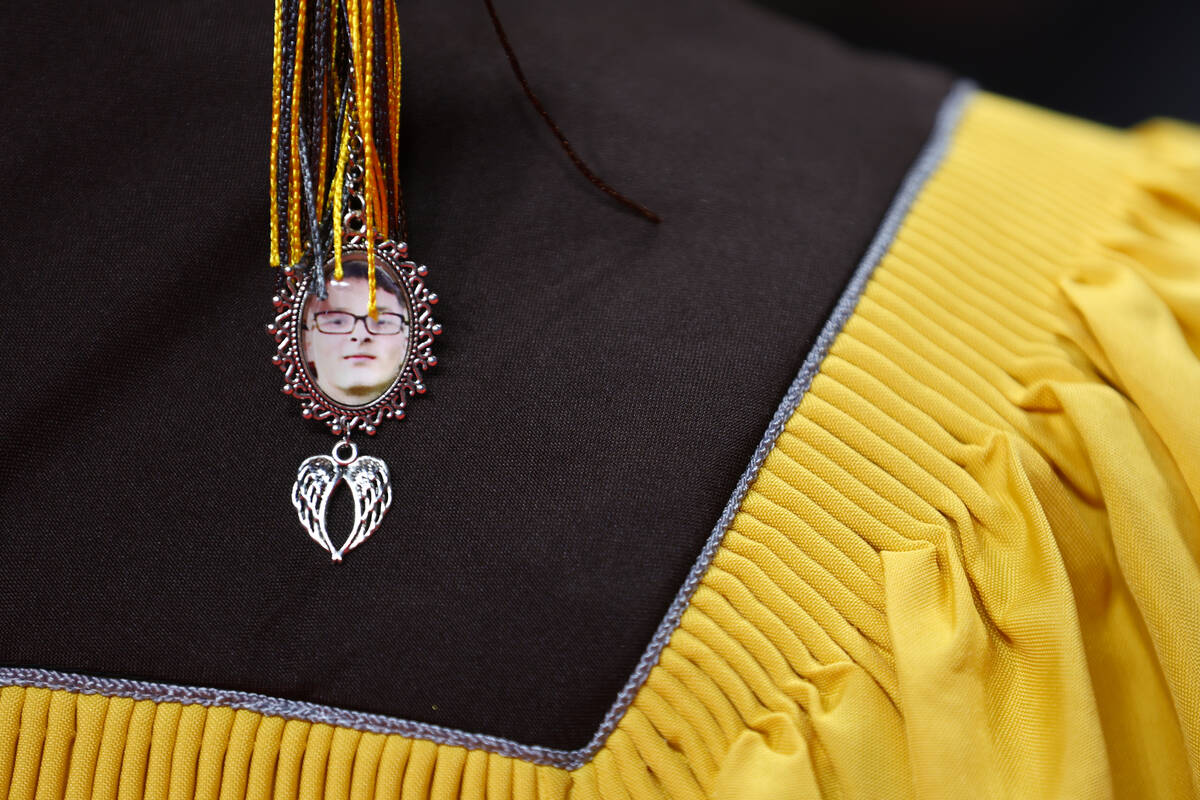 Ulysses Santana wears a tassel intertwined with a photo of his best friend, Keanu Enright, befo ...