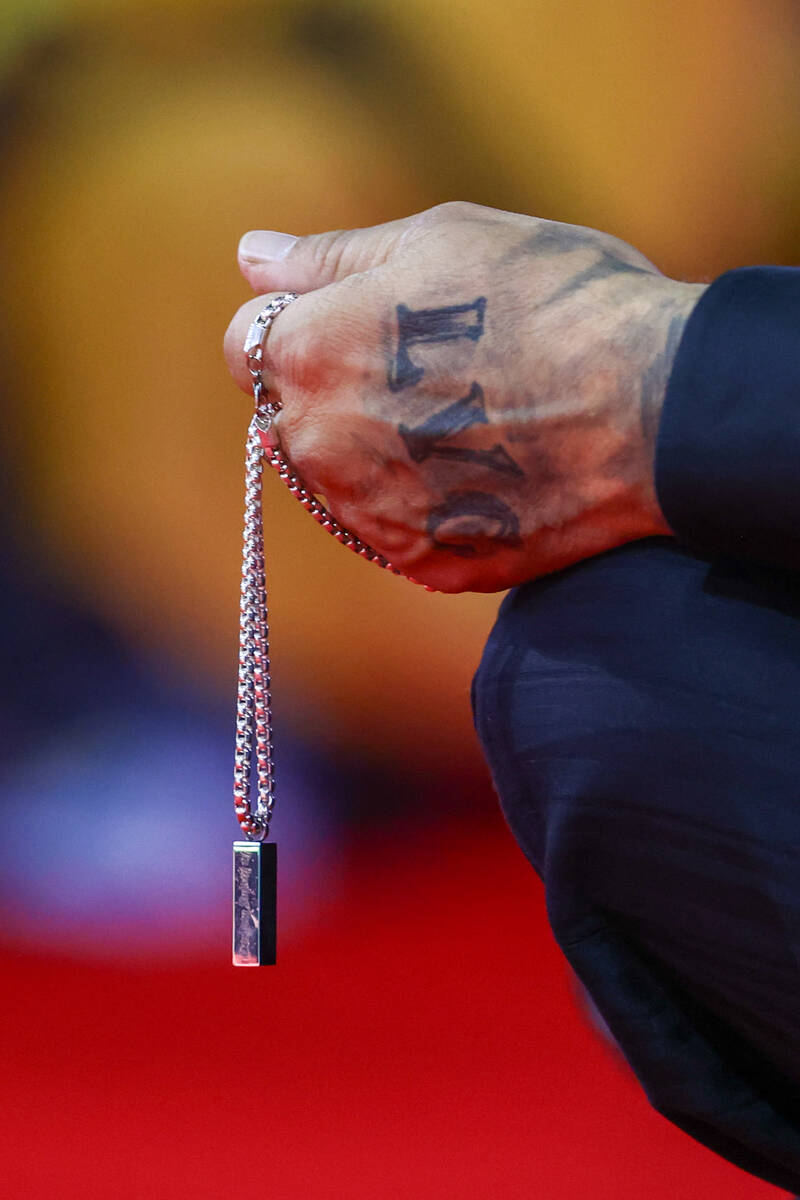 Thomas Enright grips a necklace containing his son Keanu Enright’s ashes while watching ...