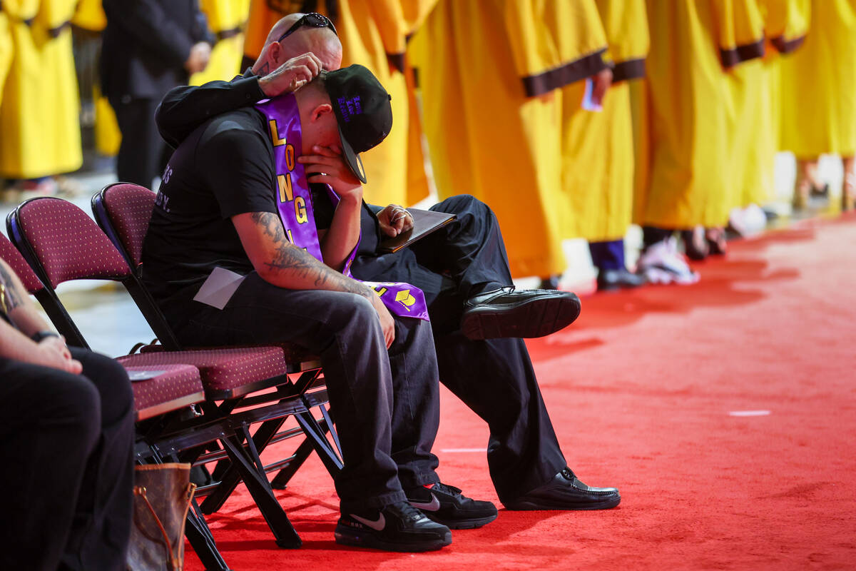 Thomas Enright, comforts TJ Enright after the two accepted Keanu Enright’s diploma on his beh ...