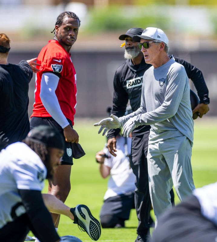 Raiders quarterback Geno Smith (7) chats with head coach Pete Carroll and others as the team wa ...