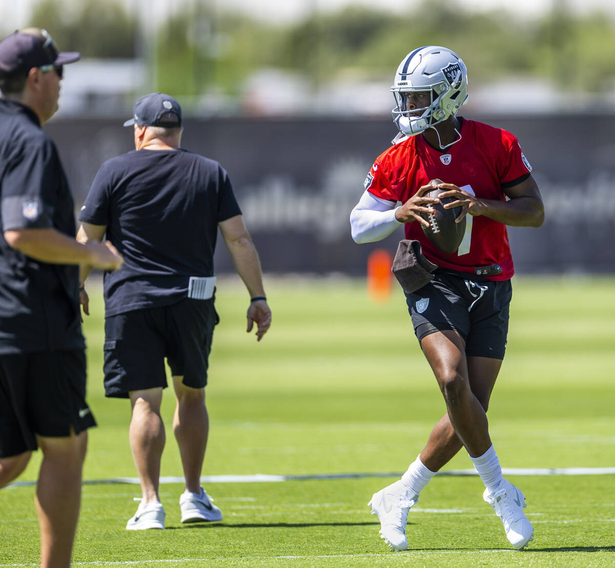 Raiders quarterback Geno Smith (7) steps back lightly while looking for a receiver during Raide ...