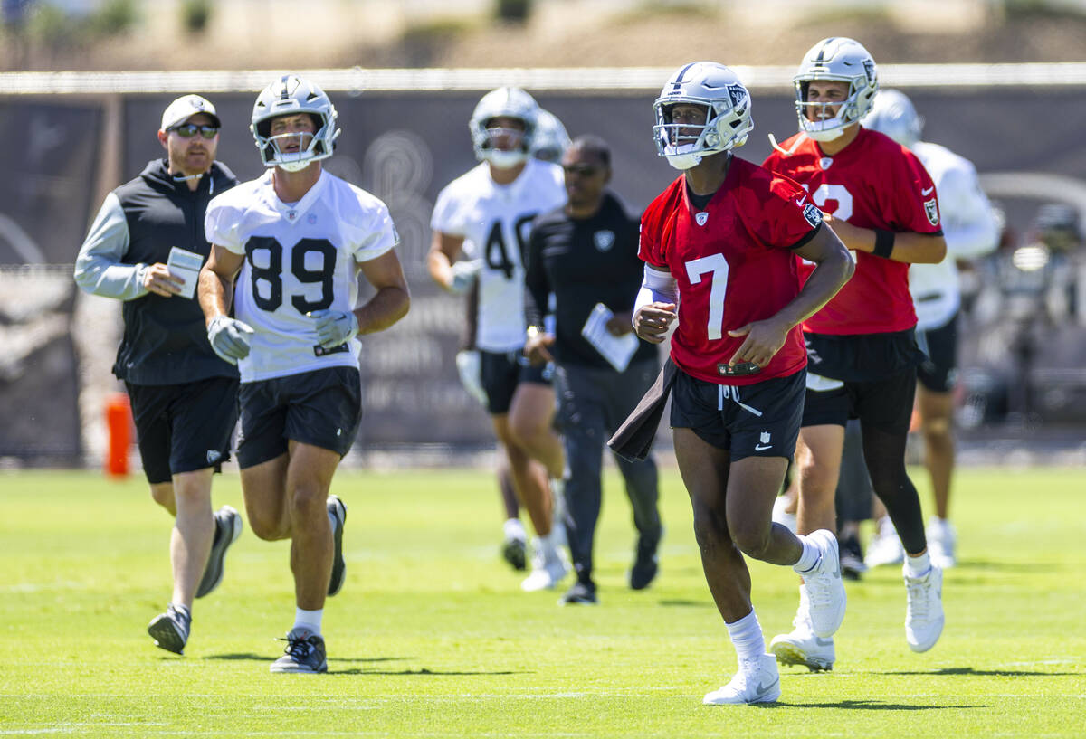 Raiders quarterback Geno Smith (7) and tight end Brock Bowers (89) move to another spot with te ...