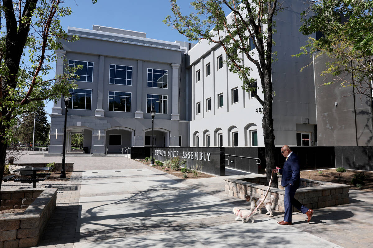 A person walks their dogs in front of the Legislative Building in Carson City Friday, May 30, 2 ...