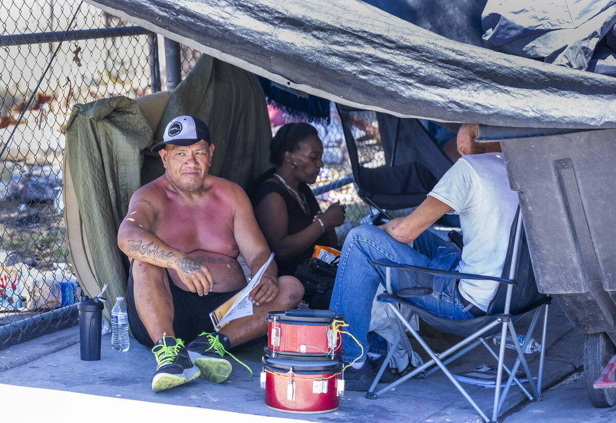 Homeless people escape the heat under a tarp shelter along North A Street in Las Vegas, Wednesd ...